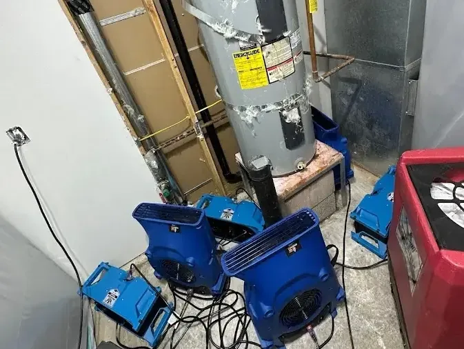 Air movers and a dehumidifier beside a water heater closet