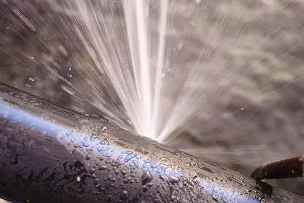 Water spraying from a split section of household supply pipe